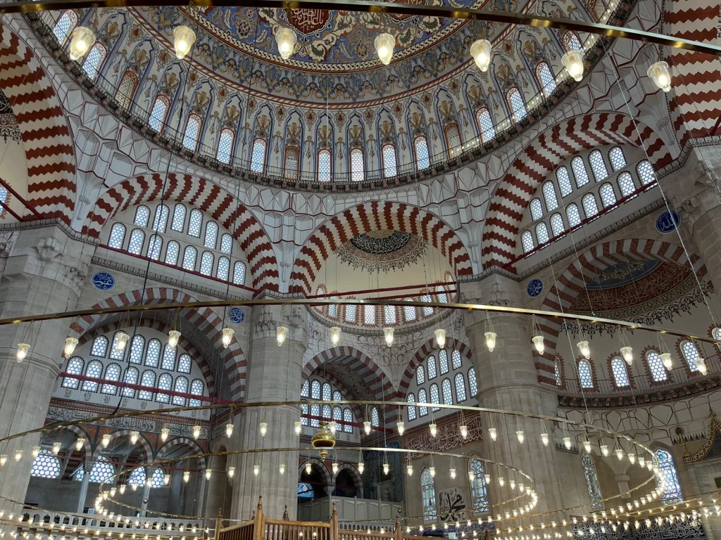 (0:00-0:10) Giriş
Edirne’nin kalbinde, Selimiye’nin gölgesinde ama ondan çok daha derin bir ruh... Osmanlı’nın Fetret Devri’ndeki varoluş mücadelesinin abidesi: Eski Cami.

(0:10-0:25) Tarih ve Mimari
1403’te temeli atılan bu yapı, tam 11 yılda tamamlandı. Dokuz devasa kubbesi ve iç mekandaki dört büyük fil ayağıyla 